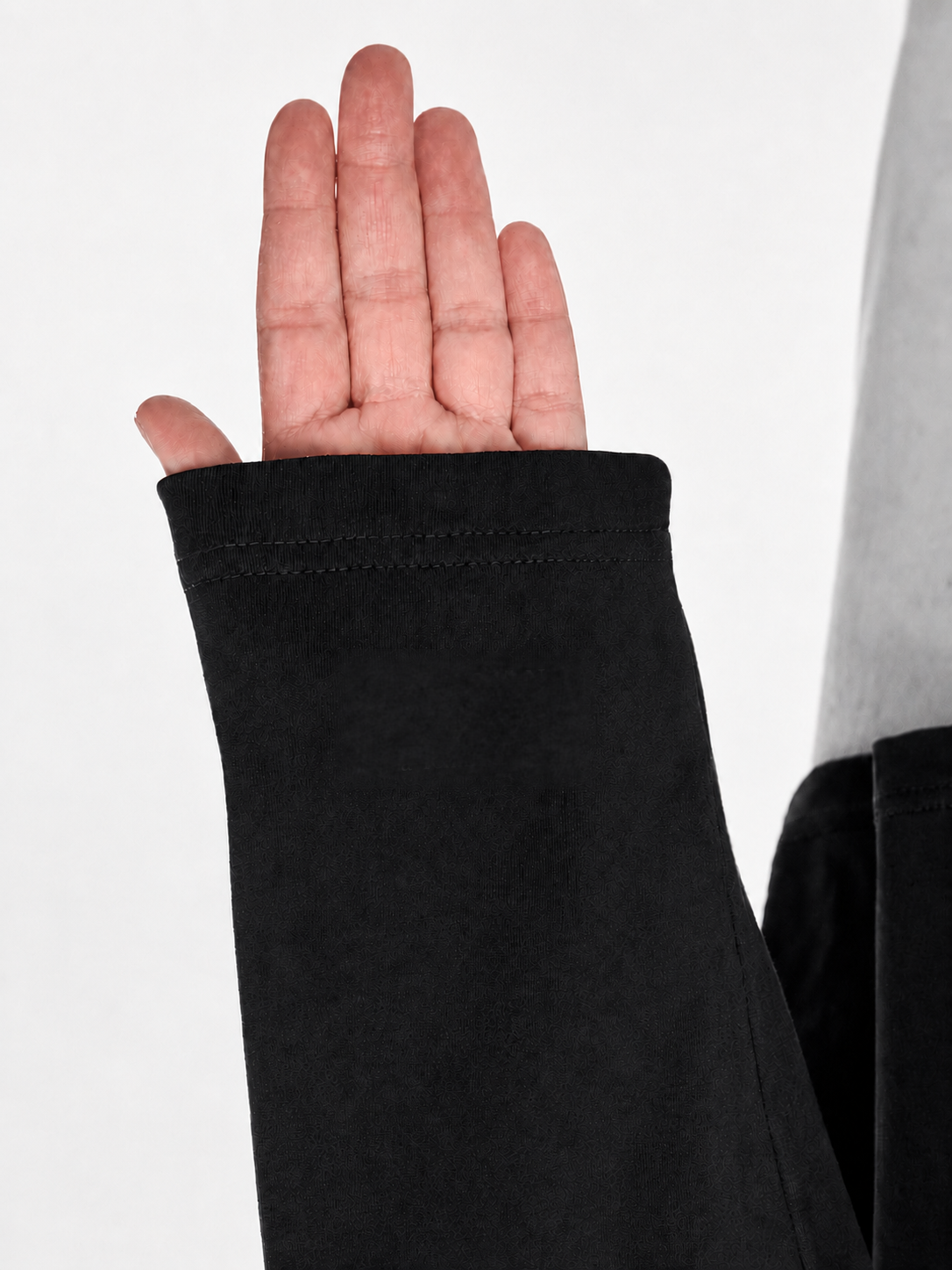 Raised hand in a long sleeve with “your reminder here” printed on the left sleeve near the wrist