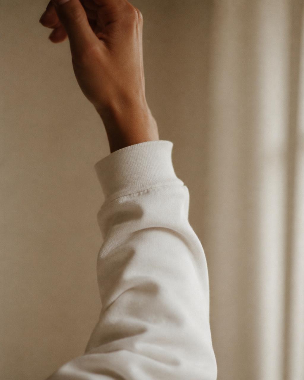 Close-up of a raised hand with the reminder printed down the right sleeve — “be brave”